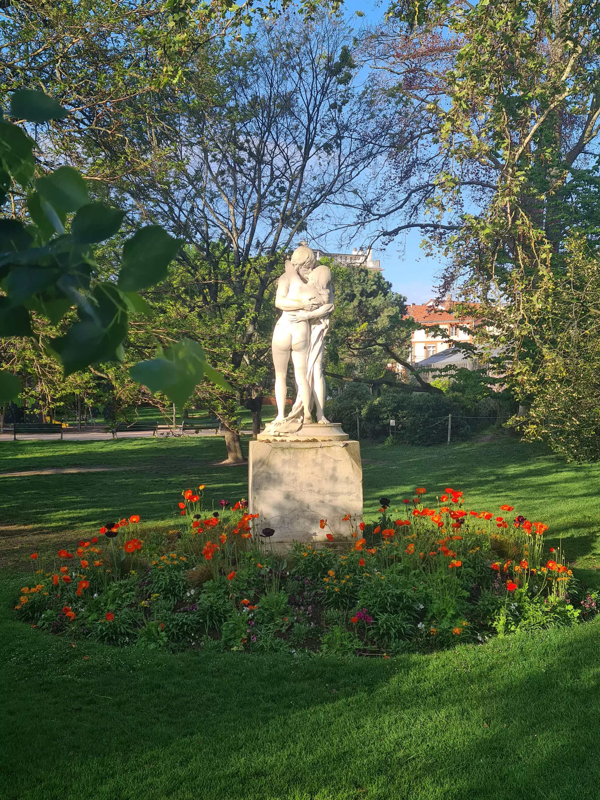 Visite guidée : statue dans le jardin des plantes entourée de fleurs