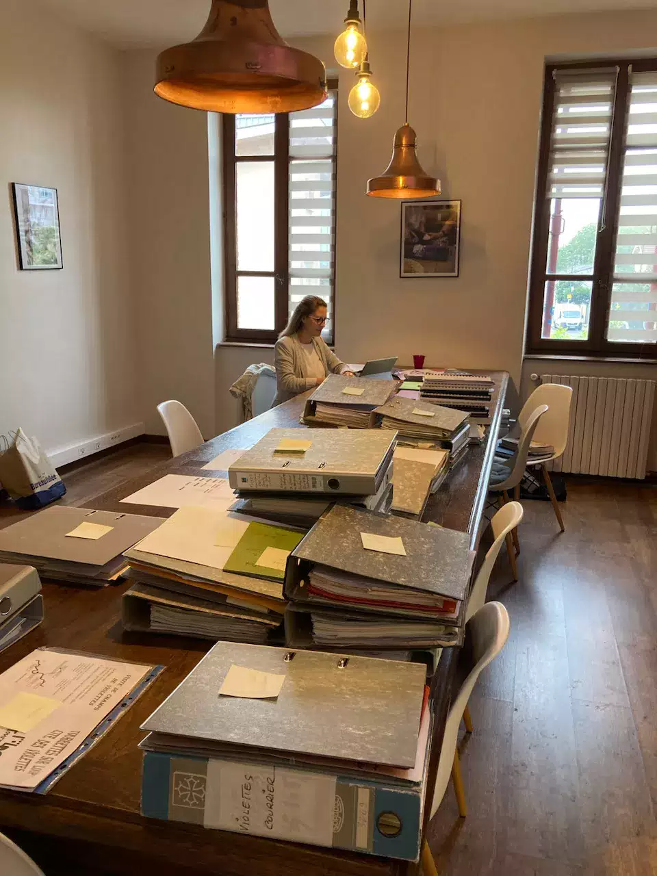 Archives d'entreprise de la Maison de la Violette en cours de classement et réparties sur une grande table 