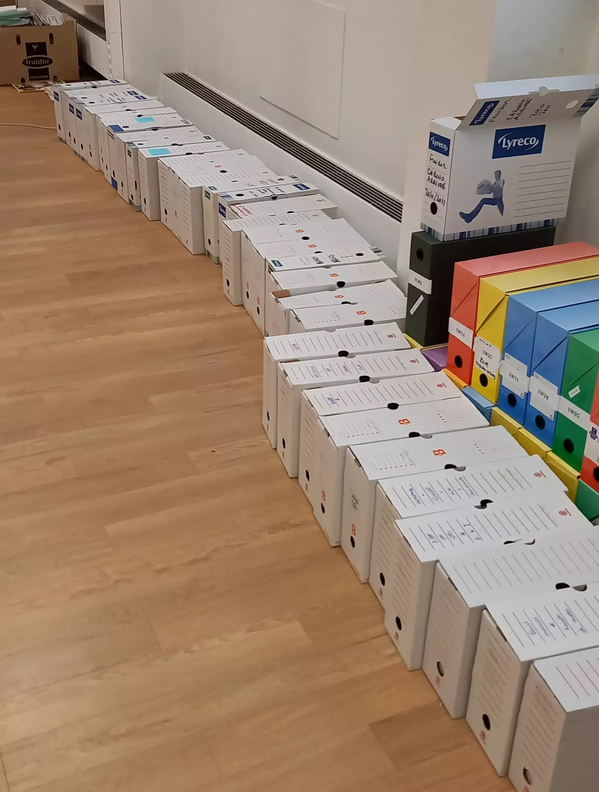 Classement des archives d'entreprise de l'UGPBAN : boîtes d'archives alignées sur le sol